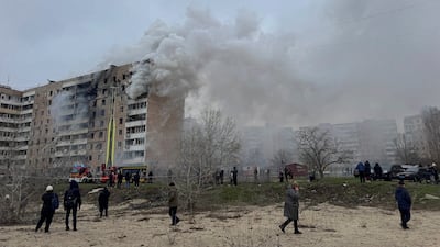 Residents walk in front of an apartment building hit by a Russian air strike in the Ukrainian city of Zaporizhzhia on Wednesday. Reuters