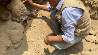 An archaeologist works to recover the remains of one of 14 pre-Incan mummies found at an archaeological complex in Peru on February 13, 2022. Reuters