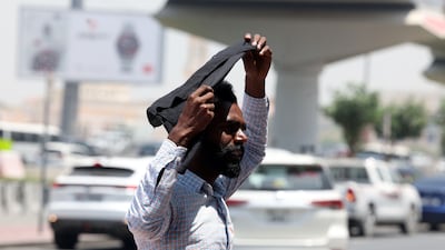 A Dubai resident covers up to protect himself on a hot, dusty day. Chris Whiteoak / The National