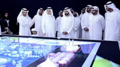 Sheikh Mohammed bin Rashid, centre, inspects a model of a solar plant. He has the same tendency as a leader to micro-monitor projects as his father did. Reuters