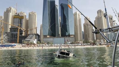 A sunken yacht being salvaged by its owner, Mohamed Irfan, and some volunteer divers off the beach on JBR. Antonie Robertson/The National