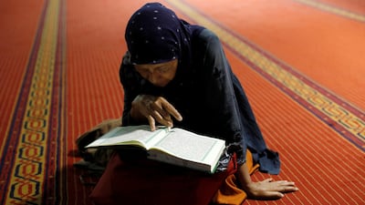 A muslim woman reads the Quran after morning prayer at Istiqlal mosque in Jakarta, Indonesia. Reuters