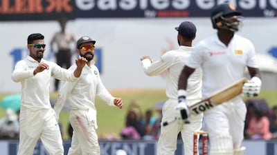 India celebrate the dismissal of Sri Lanka captain Angelo Mathews during the fourth day of the first Test at Galle on Saturday. Ishara Kodikara / AFP
