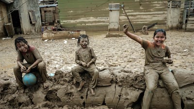 Children wait to receive aid in Babo, Indonesia, following a flash flood. AFP