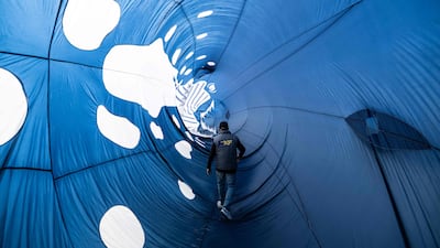 A participant walks through a kite depicting a whale while taking part in the 39th International Kite Festival at the beach of Berck-sur-Mer, northern France. AFP