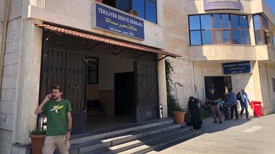 Foreign journalists and aid workers gather at the border crossing between Iraq and Syria, as they wait for their exit stamp to leave the Kurdish areas, in Semelka, northeast Syria. The border crossing between Iraq and Syria's Kurdish-held northeastern Syria was dreary on Monday. The truck lane of the usually bustling commercial gateway was empty_ only a single pick-up stood in the parking lot with sheep in the flatbed. AP Photo