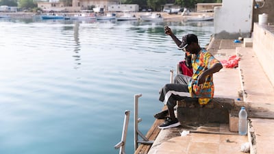 Two men fish in Dibba Fujairah’s port.