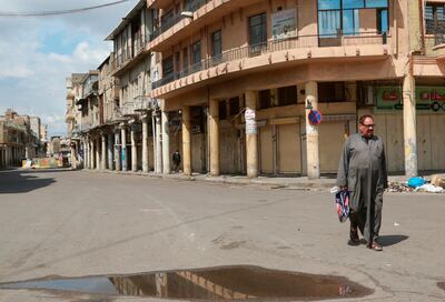 A man walks past shops that are shuttered to help prevent the spread of the coronavirus, in central Baghdad, Iraq, last week. AP Photo