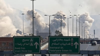Vehicles drive along an expressway against the backdrop of smoke rising after a strike on the Iranian capital of Tehran on March 5. AFP