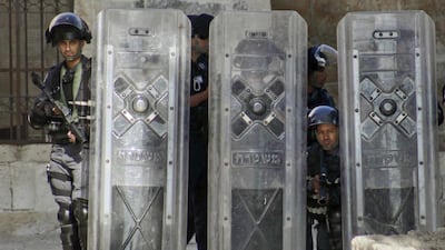 Israeli border police take cover during clashes with Palestinian youth at Al Aqsa mosque compound in Jerusalem on June 28, 2016. Israeli police on Tuesday banned non-Muslims from the site, until the end of the Muslim holy month of Ramadan following repeated clashes with Palestinians. Mahmoud Illean/AP Photo