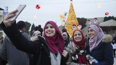 Palestinian Muslim women from Ramallah take a selfie by the Christmas tree in Bethlehem’s Manger Square on December 23, 2016. Heidi Levine for The National