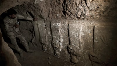 An Iraqi soldier examines carvings in the tunnels. Two winged bulls dating from the Assyrian empire were found in the network dug by ISIS to carry out archaeological excavations. AFP