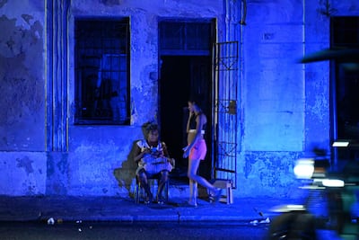 A woman checks a mobile phone during a blackout in the Centro Habana neighbourhood in Havana. AFP