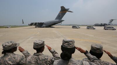 US Army soldiers salute as vehicles carry remains of American servicemen. Getty Images