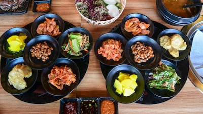 South Korean side dishes made up of kimchi, soy peanuts and salads to go along with the barbecue at Mukbang Shows restaurant. Khushnum Bhandari / The National