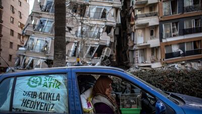 A woman holds a cage with her pet bird as she leaves the Turkish city of Hatay with her husband after a powerful earthquake that toppled thousands of buildings. EPA