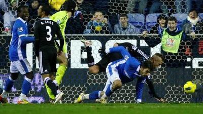 Wigan’s Jordi Gomez, second right, scores against Chelsea.