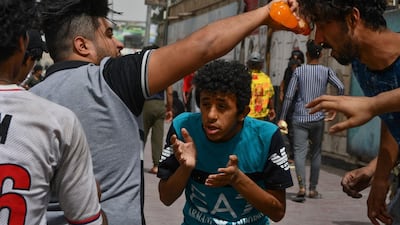 Iraqi protesters affected by smoke grenades receive help amid clashes with security forces following an anti-government demonstration in Iraq's southern city of Nasiriyah in Dhi Qar province. AFP