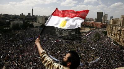 An Egyptian protester waves his national flag as tens of thousands gather for a demonstration at Cairo's Tahrir Square on April 8, 2011, two months after president Hosni Mubarak was ousted, to demand that former regime officials including the veteran stro???