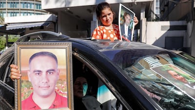 Family members of victims hold up portraits during the demonstration outside the Justice Palace in Beirut. AFP