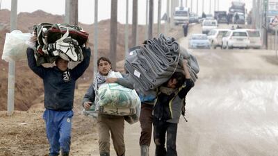 Syrian refugees carry blankets at the UN-run Zaatari refugee camp, north east of the Jordanian capital Amman, as a fierce winter storm lashed the Levant. Khalil Mazraawi / AFP