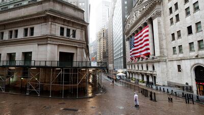 People walk along a quiet Wall Street past the New York Stock Exchange in New York. Despite the IMF expecting the US to contract by 5.9 per cent this year, markets have rallied in recent days. EPA