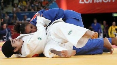 Wojdan Shaherkani of Saudi Arabia (in white) fights against Mojica Melissa of Puerto Rico during their women's judo -78kg elimination round. EPA