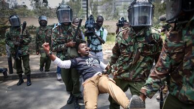 An activist Boniface Mwangi struggles as he is grabbed by police during a demonstration against recent police brutality that killed some opposition protesters, in Nairobi, Kenya. Dai Kurokawa / EPA