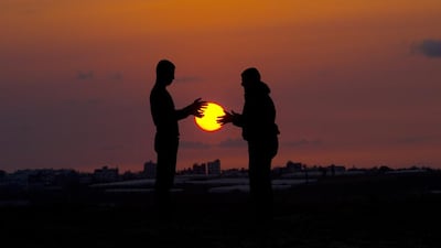 Palestinian youths play as the sun sets in Beit Hanun in the northern Gaza Strip on April 9, 2014. Mahmud Hams / AFP Photo