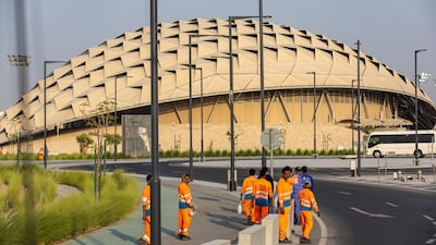 Workers outside the metro station serving the Al Thumama Stadium in Doha. Bloomberg