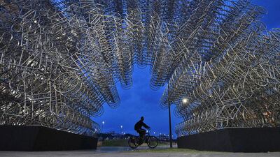 A man rides his bike past an art installation entitled "Forever Cycles" by Chinese artist Ai Weiwei in Rio de Janeiro, Brazil. AFP