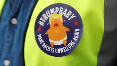 A demonstrator wears a badge depicting Trump as a baby. Reuters