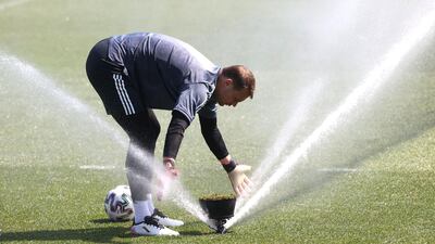 Goalkeeper Manuel Neuer washes his gloves during training. Getty