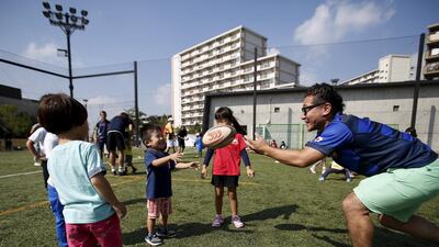 Kids play with a rugby ball during a class held by Katsushika Rugby School this month in Tokyo. Yuya Shino / Reuters