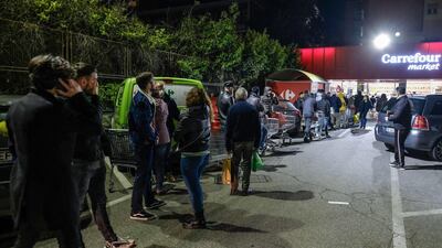 Roman citizens queue outside a supermarket as they wait to buy basic necessities, in Rome, Italy. EPA