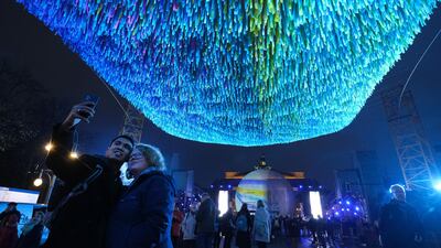 Visitors snap photos of a floating carpet of ribbons hanging in an installation by artist Patrick Shearn of the California-based artist group Poetic Kinetics during events celebrating the 30th anniversary of the fall of the Berlin Wall. Getty