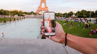 A man tries to catch a Pokemon Go character at the Trocadéro, in front of the Eiffel Tower, in Paris. The augmented-reality game ties collectable fantasy creatures to mobile-phone maps. Edward Berthelot / Getty Images