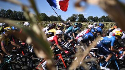 TOPSHOT - A man waves a French flag as the peloton passes by. AFP
