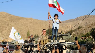 A girl scout waves Lebanon's national flag from an army vehicle on August 30, 2017, during celebrations in the eastern town of Ras Baalbek after Lebanese soldiers returned from driving ISIL out of the border region with Syria. AFP