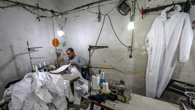 Palestinians manufacture protective coverall suits in a small sewing factory in Gaza City. EPA