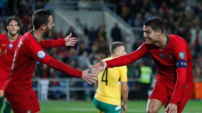 Portugal's Cristiano Ronaldo, right, celebrates with teammate Bernardo Silva after scoring his hat-trick during the Euro 2020 group B qualifier against Lithuania in Novmeber 2019. AP