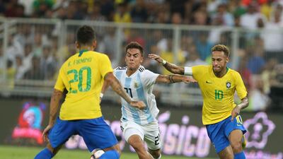 Brazil's Neymar and Roberto Firmino and Argentina forward Paulo Dybala tussle for the ball. AFP