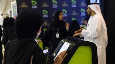 Emiratis apply for jobs at the Etisalat stand at a job fair in Fujairah. Satish Kumar / The National