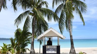 A policeman stands guard along the empty famous white beach of Boracay Island in central Philippines, as community quarantine against Covid19 still continues throughout the country, with foreign tourists still banned on beaches. AFP
