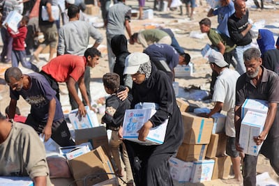 Palestinians receive food parcels after aid trucks entered from the Karem Abu Salem crossing, in Khan Yunis in the southern Gaza Strip. AFP