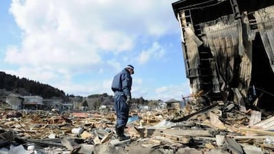 A police officer stands in silence among the debris at the destructed city of Kesennuma, northeastern Japan, on Friday. AP Photo