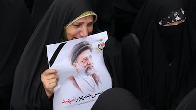 A mourner holds a portrait of Mr Raisi during a funeral procession in Tabriz, the capital of Iran's East Azerbaijan province, where the president died in a crash. AFP