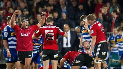 Canterbury Crusaders players Tim Perry, front left, Colin Slade, centre and Tim Perry, right, celebrate after winning on Saturday. Marty Melville / AFP / March 8, 2014