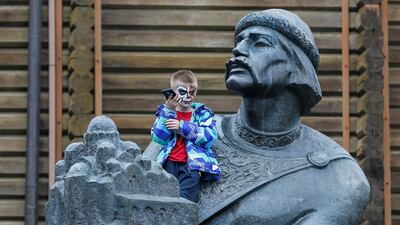 A participant sits at a monument and uses his mobile phone as he attends a Zombie Walk parade to celebrate upcoming Halloween in Kiev, Ukraine. Reuters