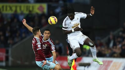 Bafetibi Gomis of Swansea City wins the ball from Aaron Cresswell and Winston Reid of West Ham United during their Premier League match on Saturday. Jan Kruger / Getty Images